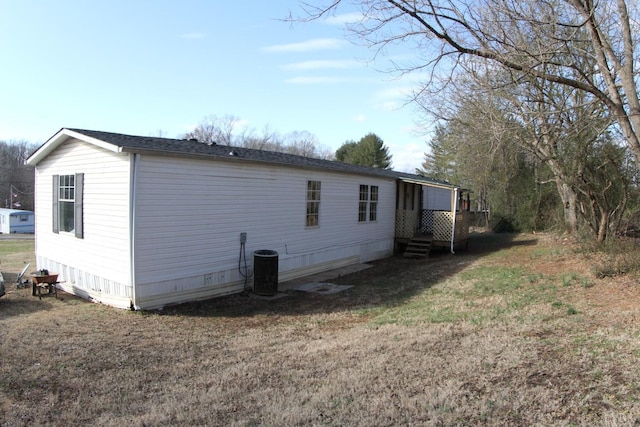 view of property exterior with a yard and central AC