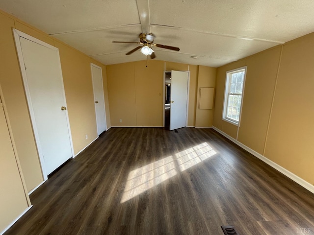 empty room with dark wood-type flooring, ceiling fan, and lofted ceiling
