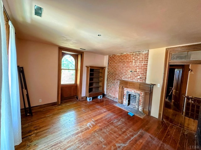 1020 Harrison St, Lynchburg, VA 24504 - unfurnished living room featuring baseboards, a brick fireplace, and hardwood / wood-style flooring