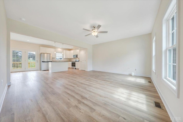 9 Lochwood Hill Dr, Goode, VA 24556 - unfurnished living room with ceiling fan, baseboards, light wood-type flooring, and a sink