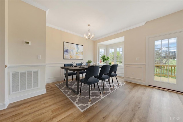 9 Lochwood Hill Dr, Goode, VA 24556 - dining area featuring a chandelier, light wood-style floors, crown molding, wainscoting, and a decorative wall