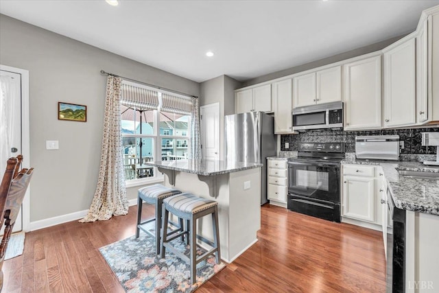 59 Broad St, Daleville, VA 24083 - kitchen with a center island, appliances with stainless steel finishes, backsplash, and light stone counters