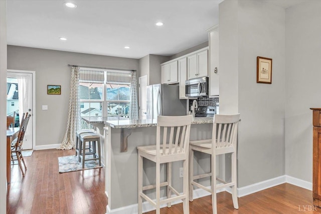 59 Broad St, Daleville, VA 24083 - kitchen featuring a peninsula, baseboards, a kitchen bar, dark wood-type flooring, and appliances with stainless steel finishes