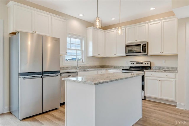 7 Lochwood Hill Dr, Goode, VA 24556 - kitchen featuring stainless steel appliances, a sink, white cabinets, a center island, and light wood-style flooring