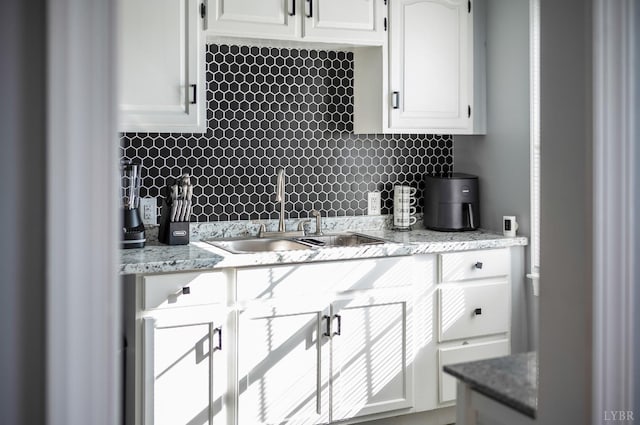 1516 Pierce St, Lynchburg, VA 24501 - kitchen with a sink, decorative backsplash, white cabinets, and light stone countertops