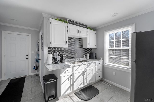 1516 Pierce St, Lynchburg, VA 24501 - kitchen featuring freestanding refrigerator, a sink, crown molding, white cabinetry, and light tile patterned flooring