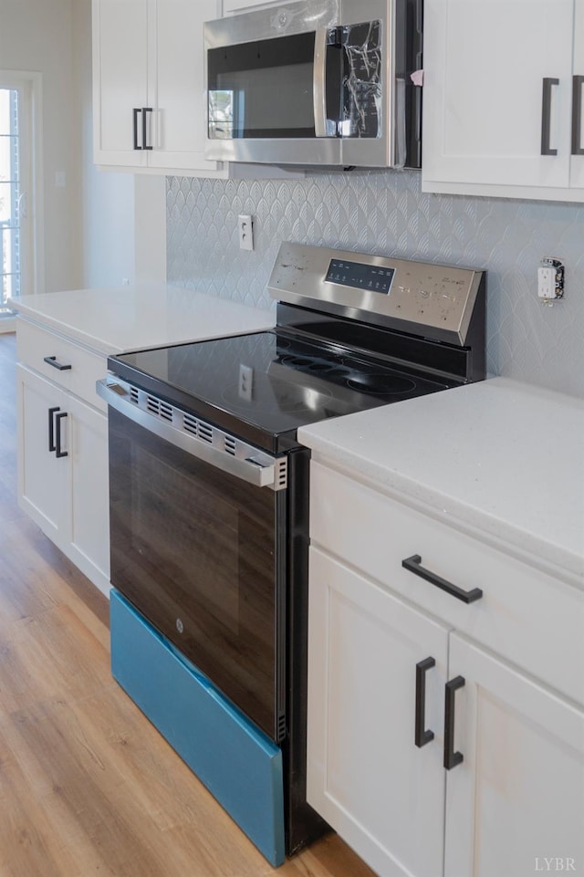 128 Brenleigh Ct Unit 202, Lynchburg, VA 24501 - kitchen featuring appliances with stainless steel finishes, light wood-type flooring, and white cabinets