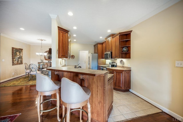 152 Fairwinds Ct, Forest, VA 24551 - kitchen with appliances with stainless steel finishes, crown molding, open shelves, a breakfast bar area, and a peninsula