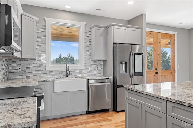 4615 Everett Rd, Forest, VA 24551 - kitchen with light stone counters, decorative backsplash, a sink, appliances with stainless steel finishes, and gray cabinets