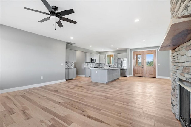 4615 Everett Rd, Forest, VA 24551 - kitchen featuring appliances with stainless steel finishes, light wood-style floors, a fireplace, a ceiling fan, and gray cabinets