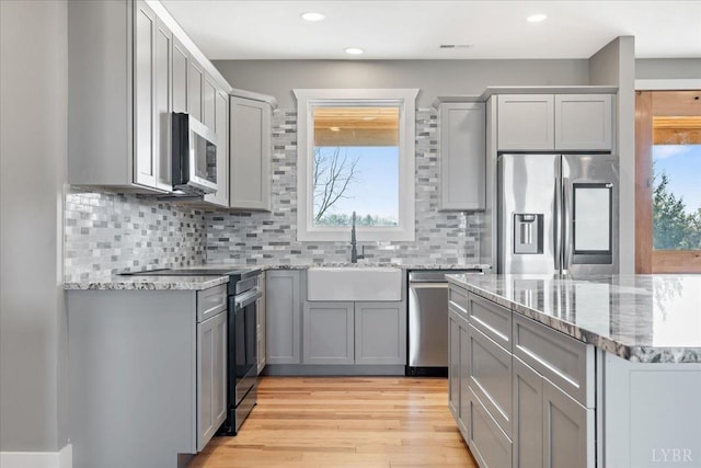4615 Everett Rd, Forest, VA 24551 - kitchen with light wood-style flooring, light stone counters, stainless steel appliances, a sink, and gray cabinetry