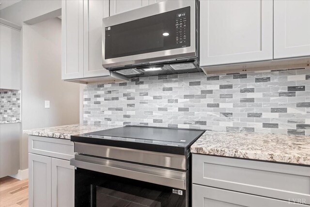 4615 Everett Rd, Forest, VA 24551 - kitchen with tasteful backsplash, light stone countertops, appliances with stainless steel finishes, and light wood-style flooring
