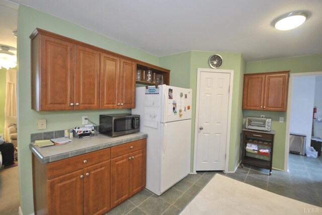 2453 Easome Rd, Hurt, VA 24563 - kitchen featuring freestanding refrigerator, stainless steel microwave, light countertops, and brown cabinets