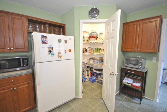 2453 Easome Rd, Hurt, VA 24563 - kitchen featuring freestanding refrigerator, stainless steel microwave, and brown cabinetry