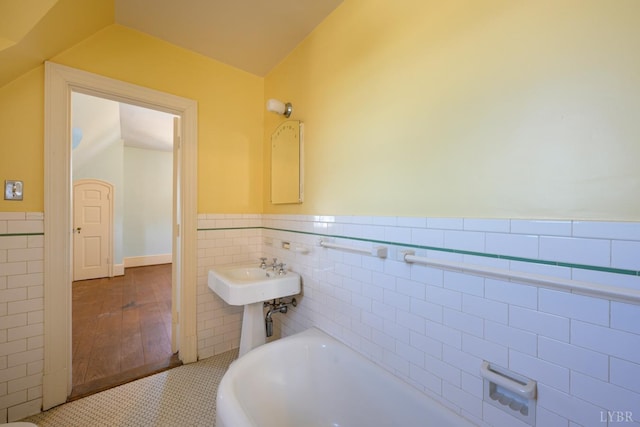 full bath featuring tile walls, wainscoting, and a bathing tub