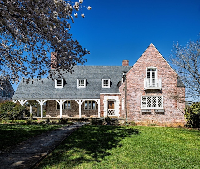 view of front facade featuring a front lawn, brick siding, and a chimney