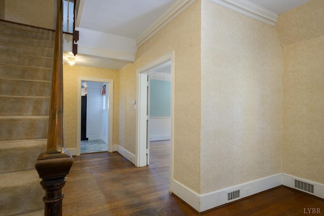hall with crown molding, baseboards, dark wood-style floors, and visible vents