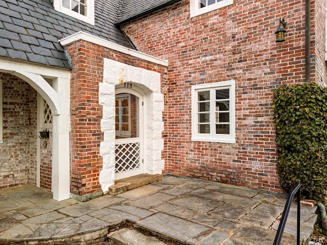 doorway to property with brick siding