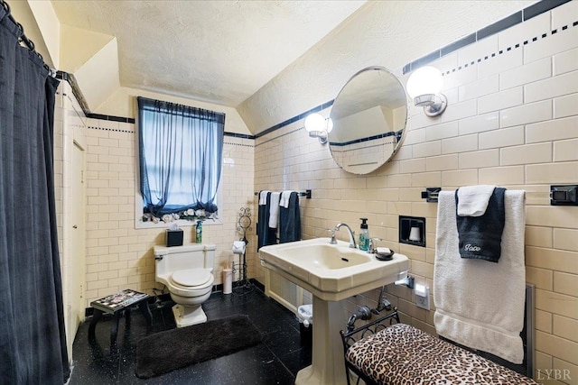1670 Church St, Appomattox, VA 24522 - bathroom featuring tile walls, a textured ceiling, vaulted ceiling, and toilet