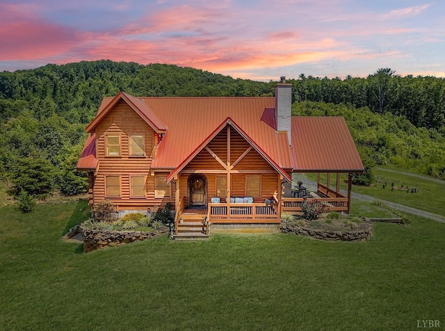 log cabin featuring a porch and a lawn