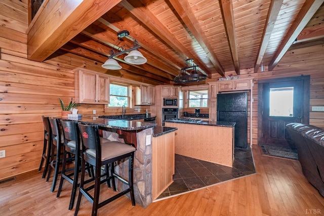2766 Camden Rd, Big Island, VA 24526 - kitchen with dark hardwood / wood-style floors, wooden walls, a center island, and black appliances