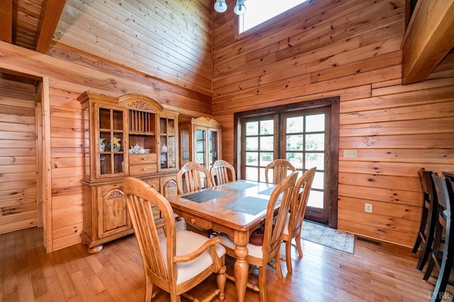 2766 Camden Rd, Big Island, VA 24526 - dining room featuring a towering ceiling, wooden walls, french doors, and light wood-type flooring