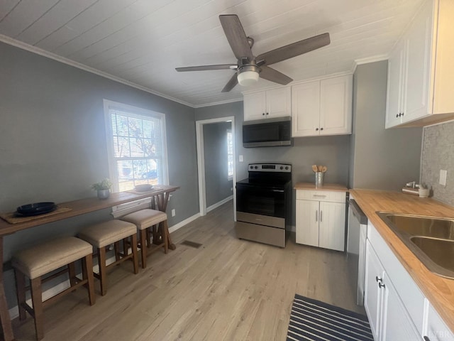 1103 Brandon Rd, Lynchburg, VA 24502 - kitchen with white cabinets, light wood-style flooring, crown molding, stainless steel appliances, and a sink