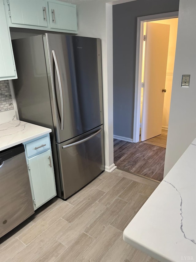 34 Cape Point Ct, Lynchburg, VA 24502 - kitchen featuring light stone countertops, stainless steel appliances, white cabinetry, baseboards, and light wood-type flooring