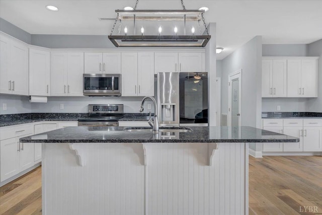 1270 Hupps Hill Ln, Forest, VA 24551 - kitchen with stainless steel appliances, light wood-style flooring, a sink, white cabinetry, and a breakfast bar area