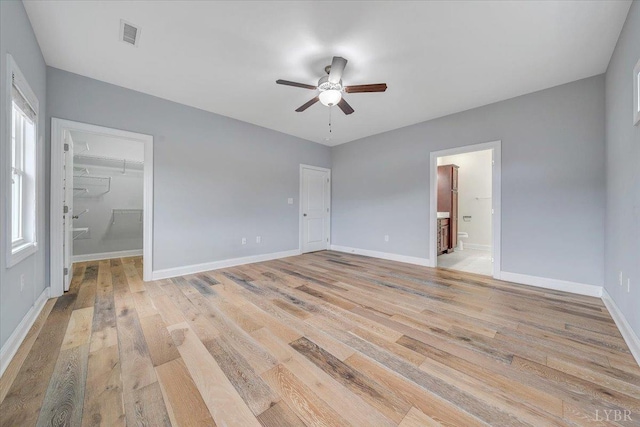 1270 Hupps Hill Ln, Forest, VA 24551 - unfurnished bedroom with light wood finished floors, connected bathroom, baseboards, a spacious closet, and a ceiling fan