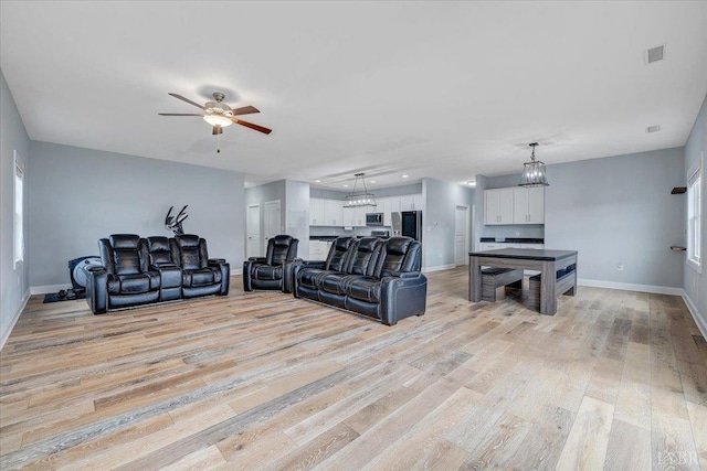 1270 Hupps Hill Ln, Forest, VA 24551 - living area with baseboards, light wood-style flooring, a chandelier, and a ceiling fan