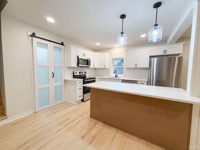 13273 Leesville Rd, Lynch Station, VA 24571 - kitchen with white cabinets, light countertops, a sink, light wood-type flooring, and appliances with stainless steel finishes