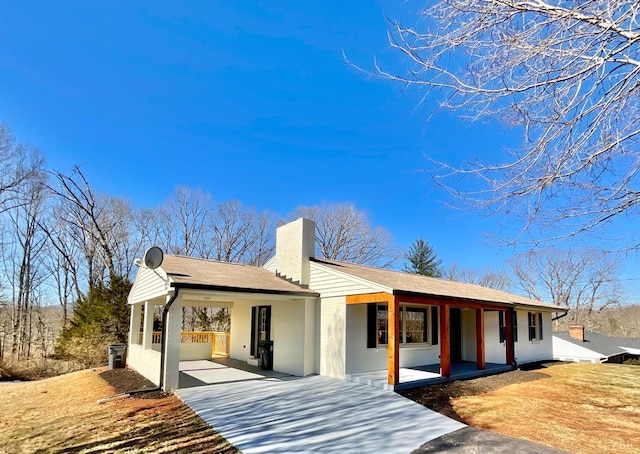 143 Lake Dr, Amherst, VA 24521 - rear view of house featuring a porch, concrete driveway, a chimney, and a carport