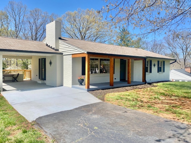 143 Lake Dr, Amherst, VA 24521 - ranch-style house featuring concrete driveway, a porch, an attached carport, brick siding, and a chimney
