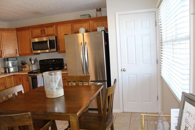 224 Duncraig Dr, Lynchburg, VA 24502 - kitchen with appliances with stainless steel finishes, light tile patterned flooring, brown cabinets, and light countertops