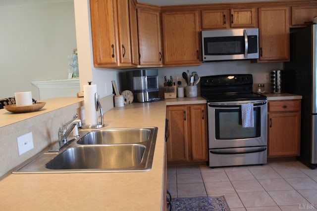 224 Duncraig Dr, Lynchburg, VA 24502 - kitchen featuring appliances with stainless steel finishes, brown cabinetry, a sink, light countertops, and light tile patterned floors