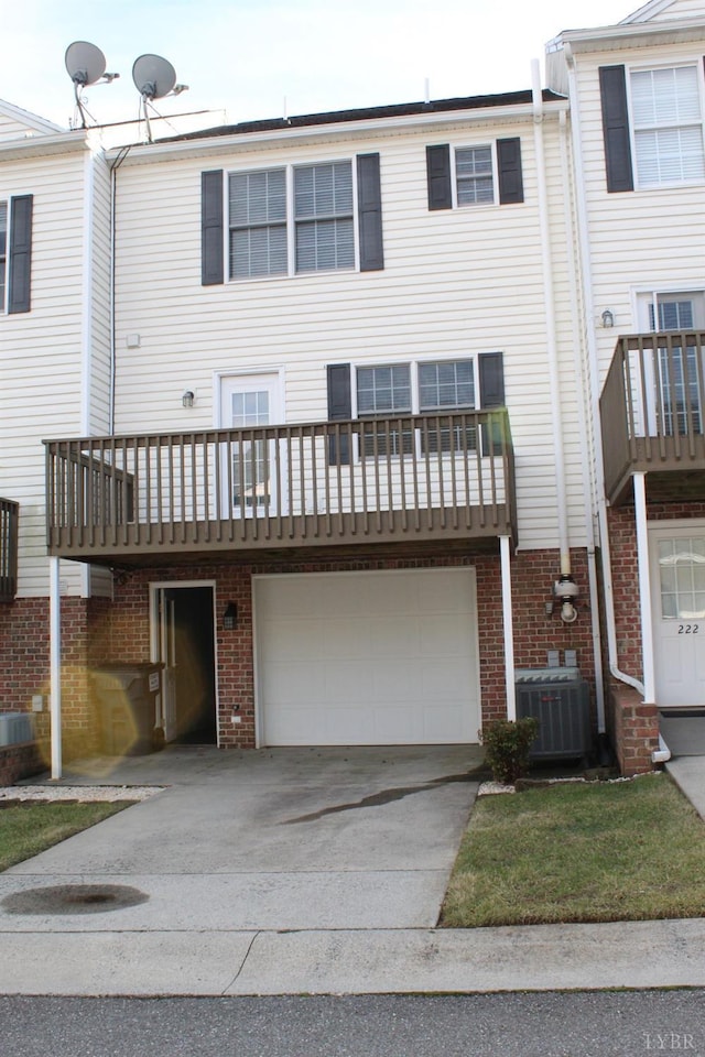 224 Duncraig Dr, Lynchburg, VA 24502 - back of house with concrete driveway, an attached garage, central AC unit, and brick siding