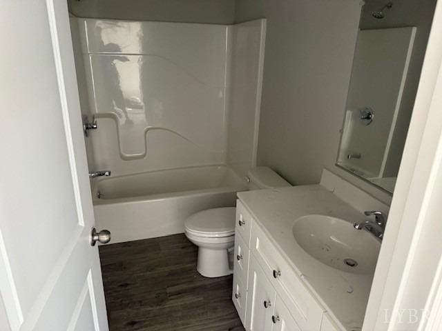 bathroom featuring vanity, toilet, wood finished floors, and tub / shower combination