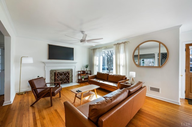 3756 Woodside Ave, Lynchburg, VA 24503 - living area featuring crown molding, a ceiling fan, light wood-style flooring, baseboards, and a fireplace with flush hearth