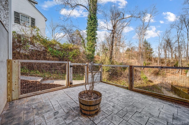 view of patio with a garden, a gate, and fence
