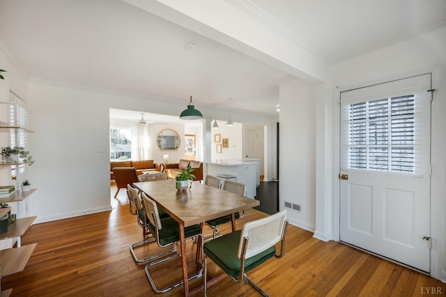 dining space featuring ornamental molding, visible vents, and wood finished floors