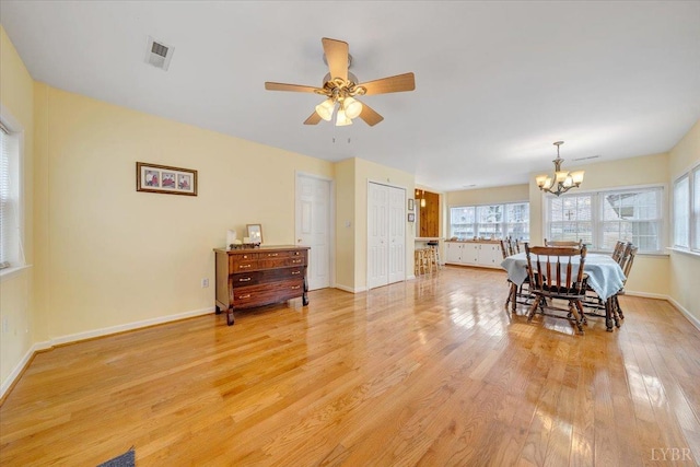 dining room featuring a chandelier, healthy amount of natural light, light wood-style flooring, and baseboards
