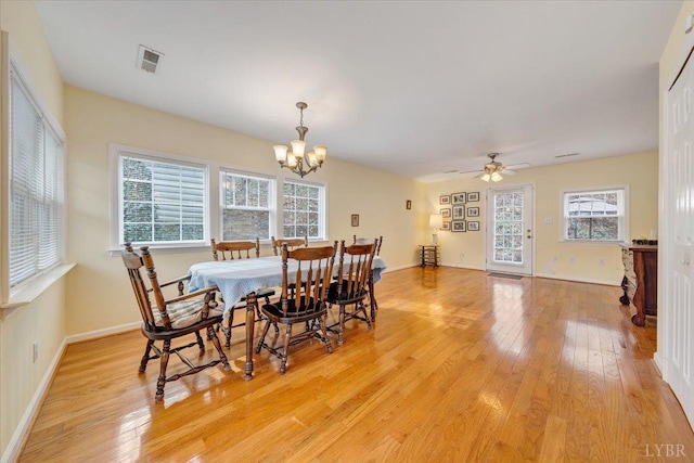 dining space featuring a chandelier, light wood-type flooring, healthy amount of natural light, and ceiling fan