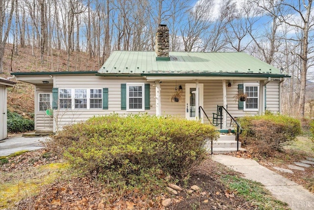 view of front of property featuring a chimney and metal roof