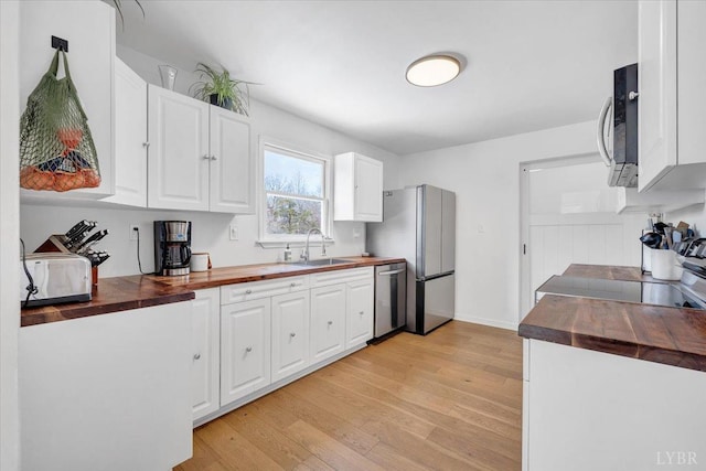 268 Leftwich Rd, Madison Heights, VA 24572 - kitchen with butcher block counters, appliances with stainless steel finishes, light wood-style floors, a sink, and white cabinetry