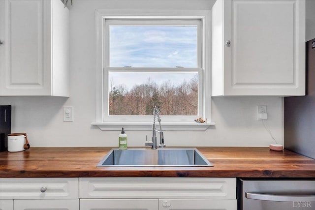 268 Leftwich Rd, Madison Heights, VA 24572 - kitchen with wood counters, a sink, stainless steel dishwasher, and white cabinets