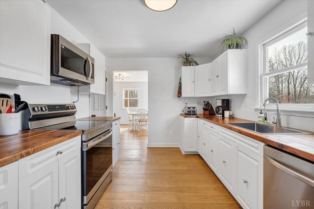 268 Leftwich Rd, Madison Heights, VA 24572 - kitchen with stainless steel appliances, butcher block countertops, a sink, light wood-style flooring, and white cabinetry