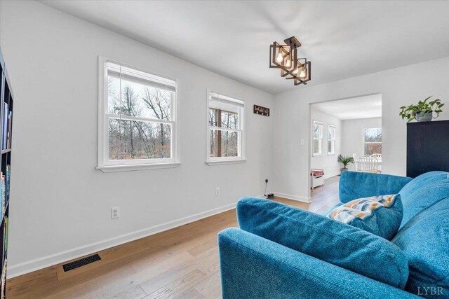 268 Leftwich Rd, Madison Heights, VA 24572 - living room featuring healthy amount of natural light, baseboards, wood finished floors, and a chandelier