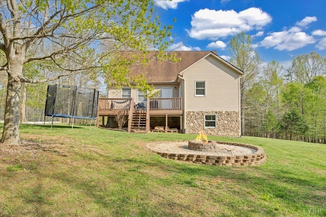 268 Leftwich Rd, Madison Heights, VA 24572 - rear view of house featuring a trampoline, a deck, a fire pit, a lawn, and stairway