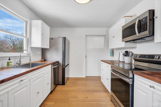 268 Leftwich Rd, Madison Heights, VA 24572 - kitchen with wood counters, stainless steel appliances, a sink, light wood finished floors, and white cabinets